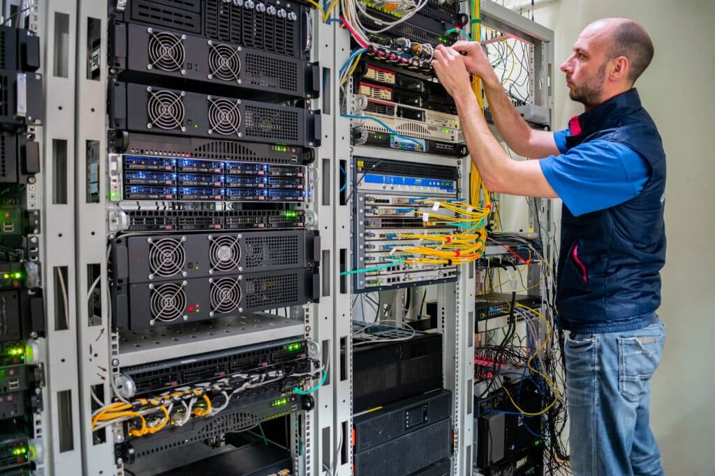 Technician works with server equipment in a data center, Shutterstock ID#2273884099.